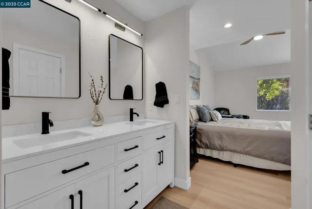 a bathroom with double vanity and a mirror