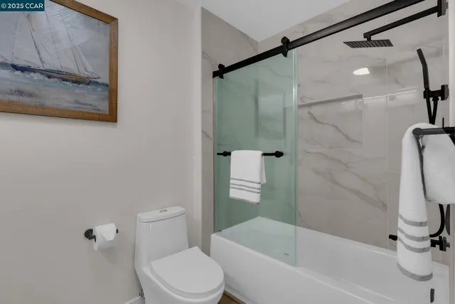 a white toilet sitting next to a bath tub and shower