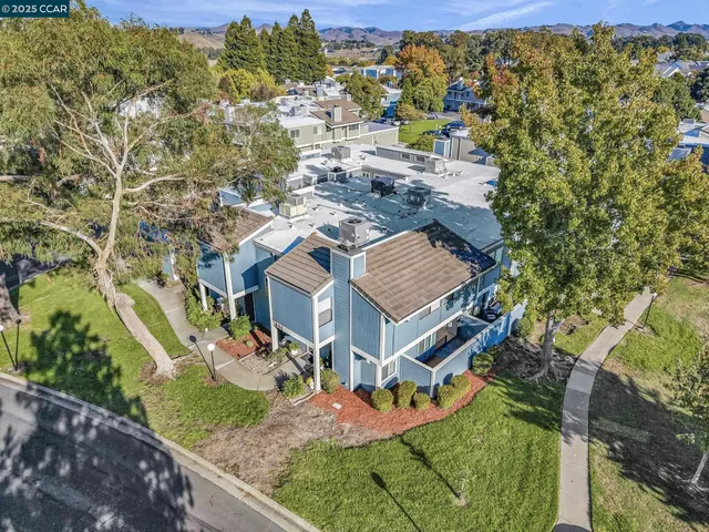 an aerial view of residential houses with outdoor space and trees