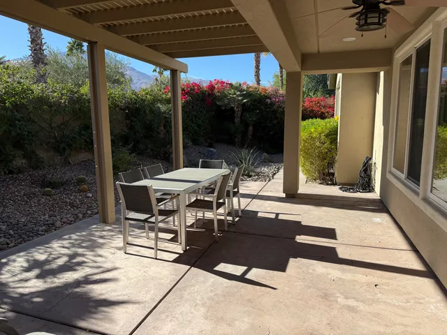 a view of a patio with a dining table and chairs