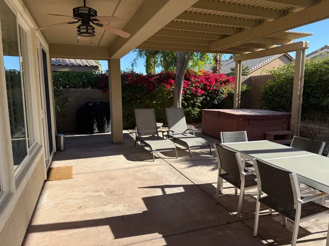a view of a dining tables and chairs in patio in front of a house