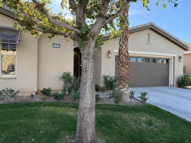 a front view of a house with a garden and patio