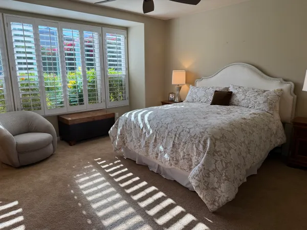 a bedroom with bed and a large window