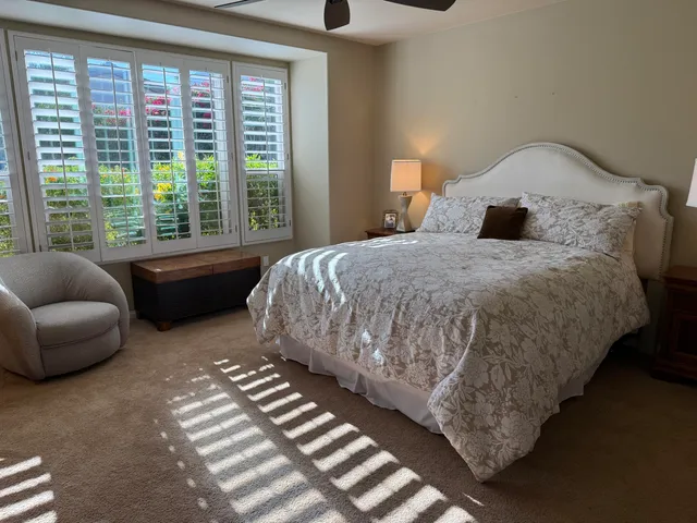 a bedroom with bed and a large window