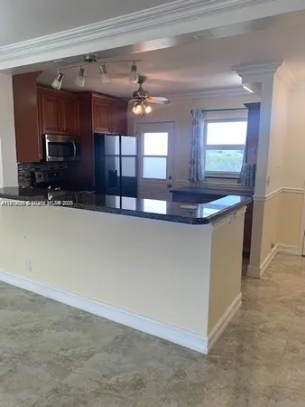 a view of a kitchen with kitchen island a sink and wooden floor