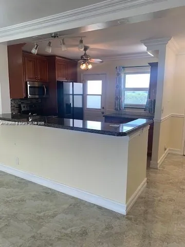 a view of a kitchen with kitchen island a sink and wooden floor