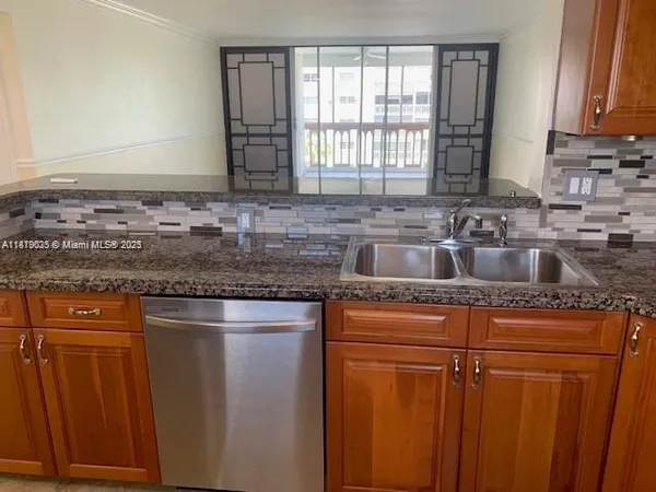 a kitchen with granite countertop cabinets sink and window