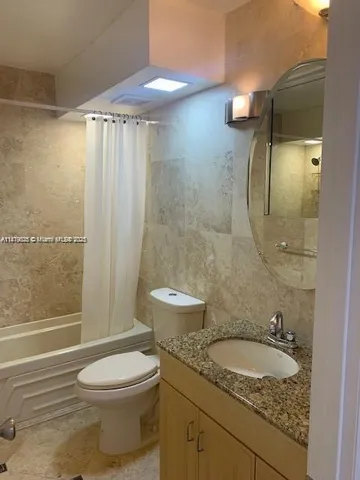 a bathroom with a granite countertop sink toilet a mirror and shower