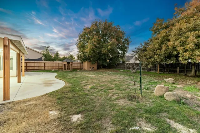 a backyard of a house with table and chairs