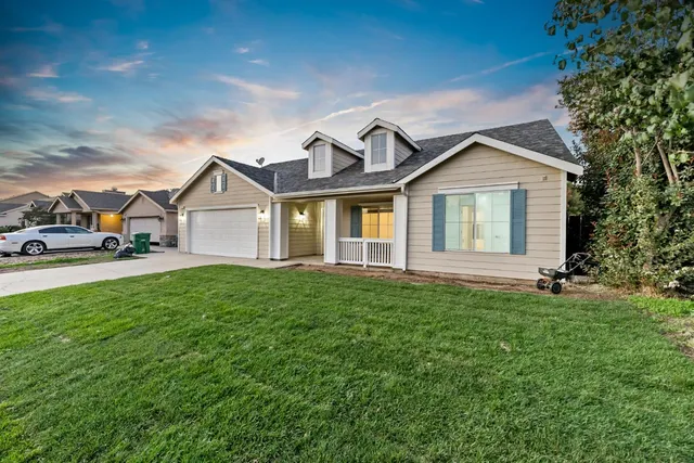 a view of a yard in front of a house with large trees