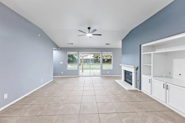 a large white kitchen with granite countertop a large window and a fireplace
