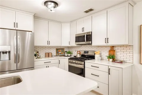 a kitchen with stainless steel appliances a refrigerator sink and cabinets