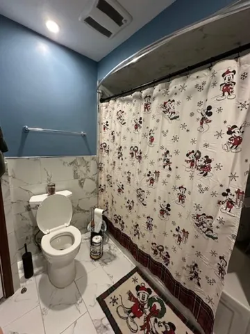 a bathroom with a toilet and a shower curtain
