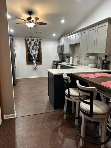 a kitchen with stainless steel appliances granite countertop a sink a stove a refrigerator and cabinets