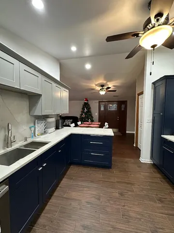 a large kitchen with stainless steel appliances a large counter top a stove a refrigerator and a sink