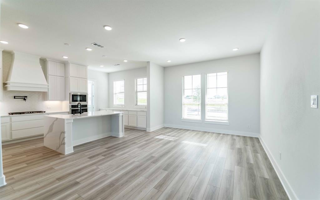 2012 Casting Ridge Mesquite, TX 75181 - Photo 9 of 28 a large white kitchen with wooden floors stainless steel appliances and white cabinets