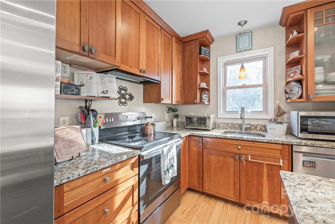 13801 East Rocky River Road Davidson, NC 28036 - Photo 21 of 42 a kitchen with stainless steel appliances granite countertop a sink a stove and cabinets