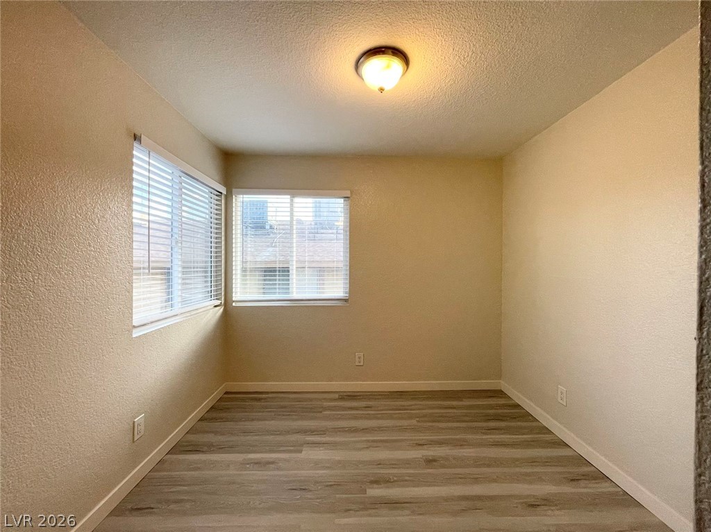 1834 North Decatur Boulevard, Unit 204 Las Vegas, NV 89108 - Photo 11 of 17 Well-lit room featuring durable laminate flooring and ample natural light through multiple windows.