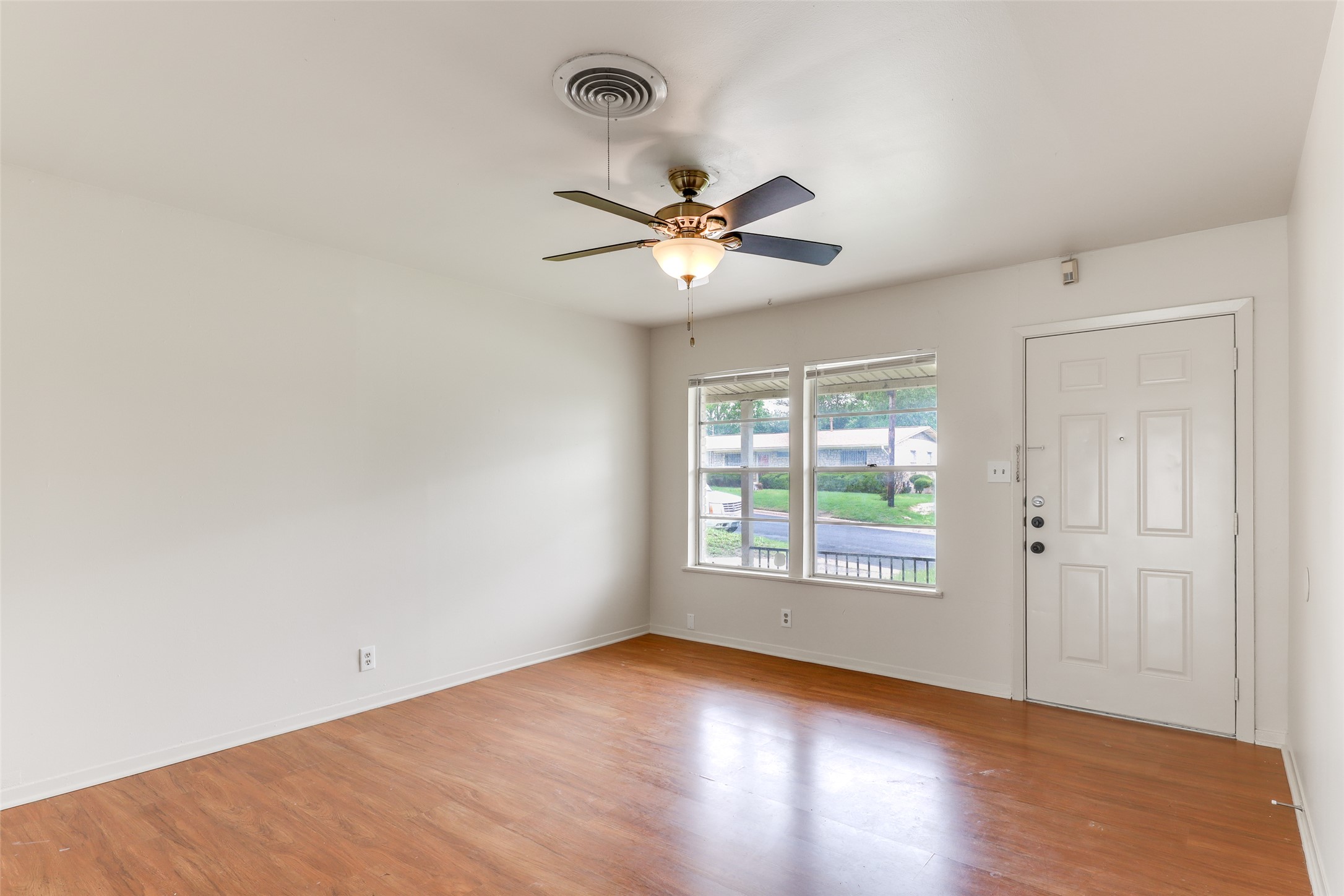 1800 Rhodes Road Austin, TX 78721 - Photo 4 of 14 an empty room with window and a ceiling fan
