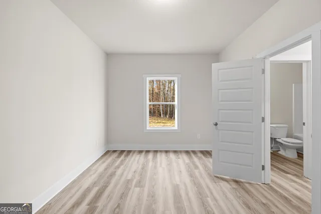 a view of hallway with a bathroom and a window