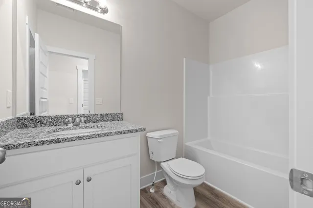 a bathroom with a granite countertop toilet a sink and a bathtub