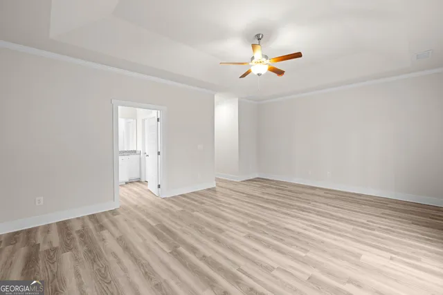 a view of empty room with wooden floor