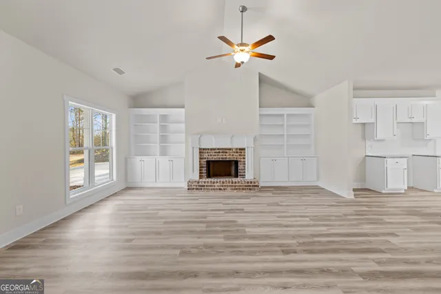 a view of an empty room with a fireplace and a window