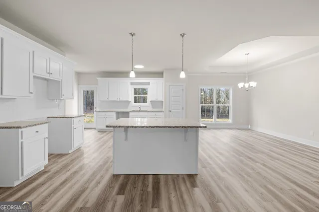 a large kitchen with kitchen island a sink stainless steel appliances and cabinets