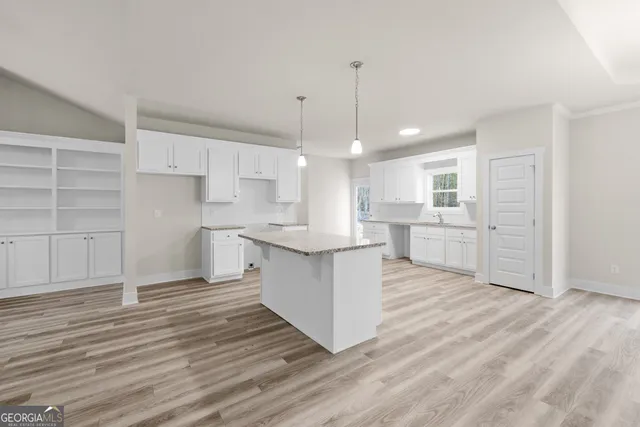 a large kitchen with cabinets wooden floor and stainless steel appliances