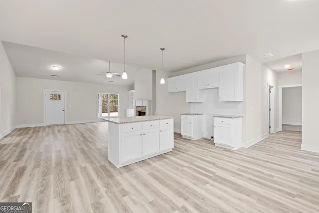 a view of a kitchen with kitchen island a sink stainless steel appliances and cabinets