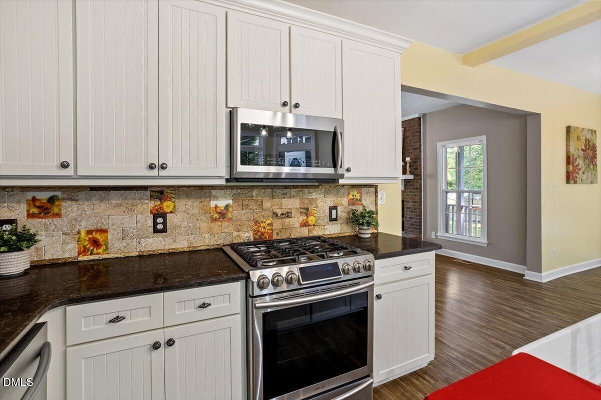 7505 Penny Road Raleigh, NC 27606 - Photo 20 of 35 a kitchen with granite countertop white cabinets and stainless steel appliances
