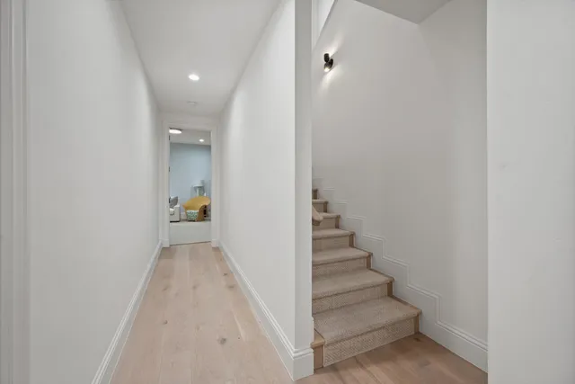 a view of a hallway with wooden floor and staircase