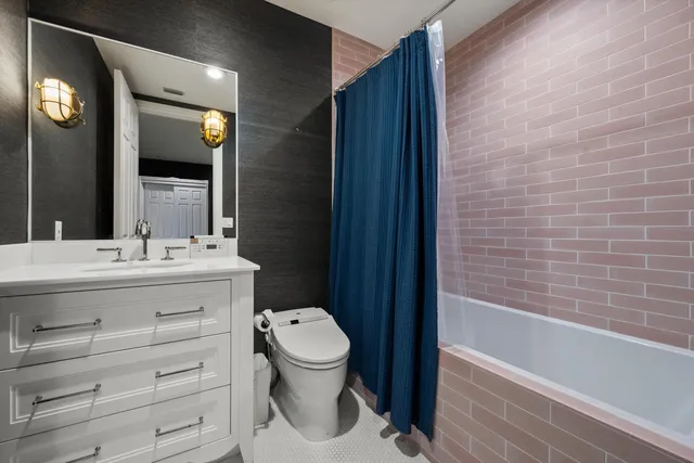 a bathroom with a sink a toilet and shower