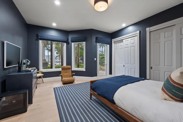 a bedroom with a bed and large windows