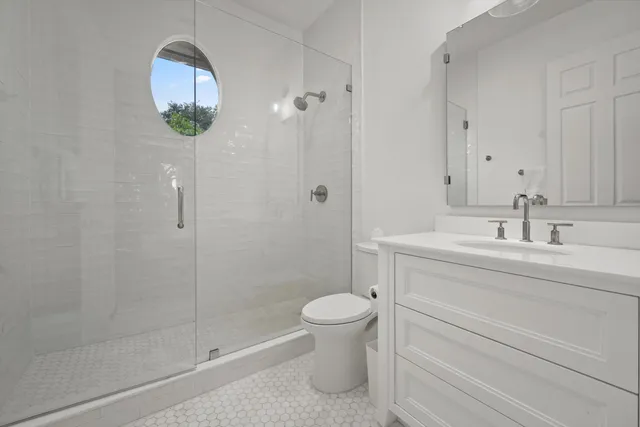 a bathroom with a sink a toilet and shower