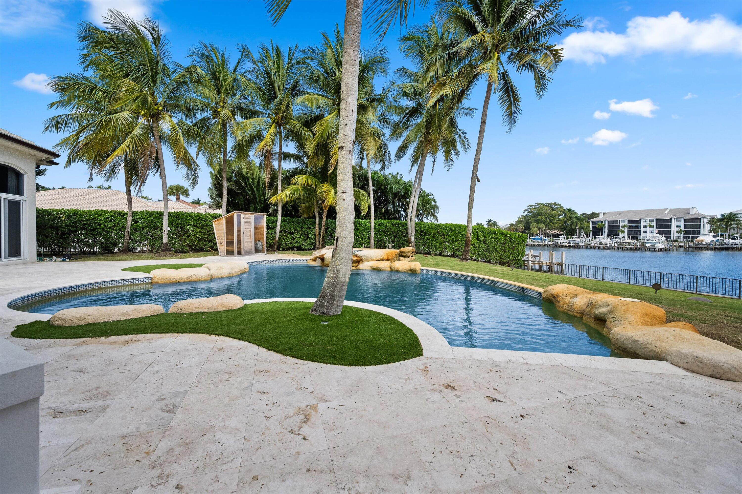 2270 Wilsee Road Palm Beach Gardens, FL 33410 - Photo 37 of 49 a view of a swimming pool with a lawn chairs and palm tree