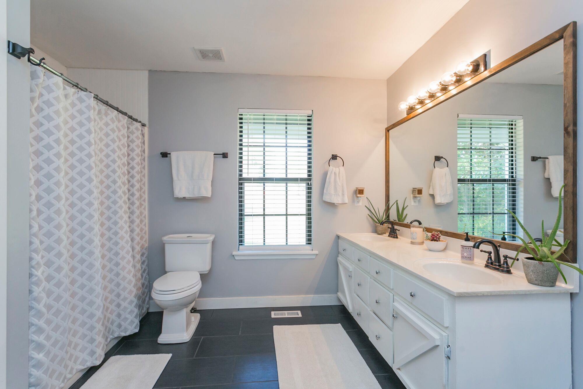 7690 Joe Rowlin Road Christiana, TN 37037 - Photo 7 of 18 a bathroom with a double vanity sink toilet and a tub