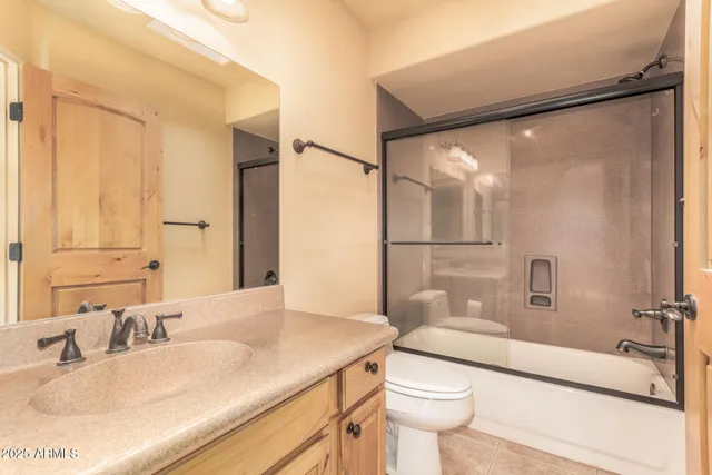 an empty room with a fireplace and a ceiling fan