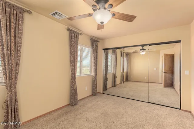 an empty room with a ceiling fan and a window