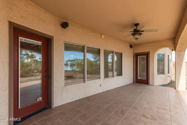 a view of a house with large trees and wooden fence