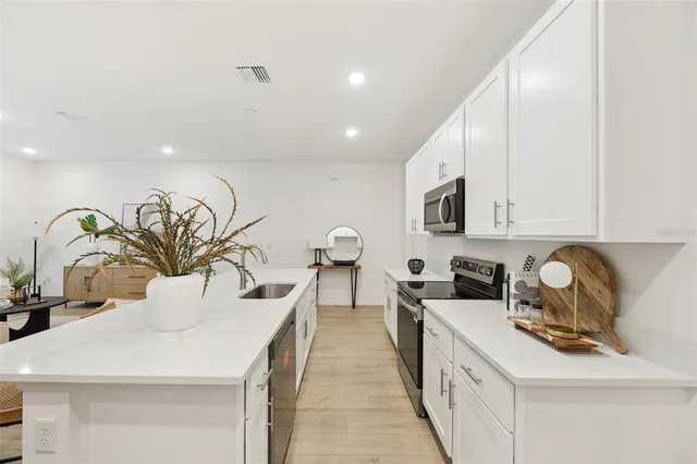 a kitchen with stainless steel appliances granite countertop a sink stove and cabinets