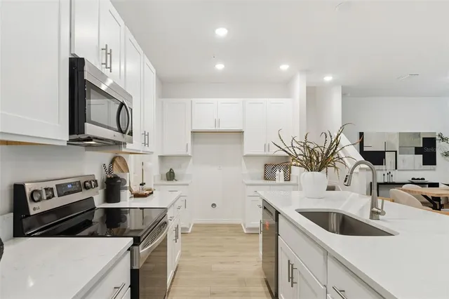a kitchen with stainless steel appliances granite countertop a sink a stove and a microwave