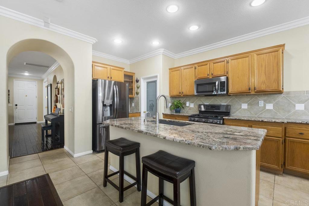 1113 Teal Way Oceanside, CA 92057 - Photo 9 of 49 a kitchen with stainless steel appliances granite countertop a stove a sink a refrigerator a microwave a refrigerator and cabinets