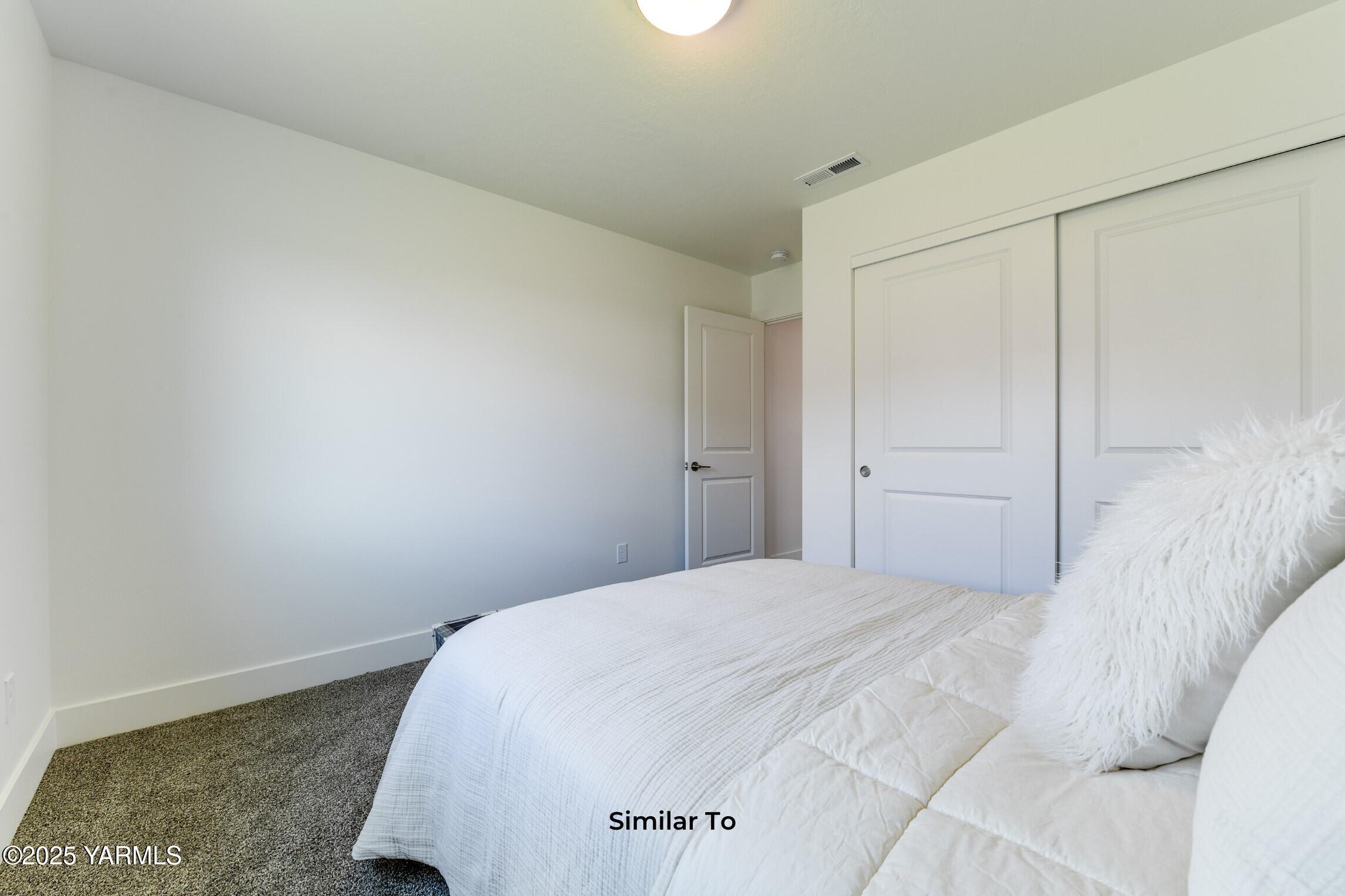 506 Grapevine Street, Unit PHASE 3 LOT 11) SPEC Grandview, WA 98930 - Photo 13 of 22 a bedroom with a bed and a white cabinet