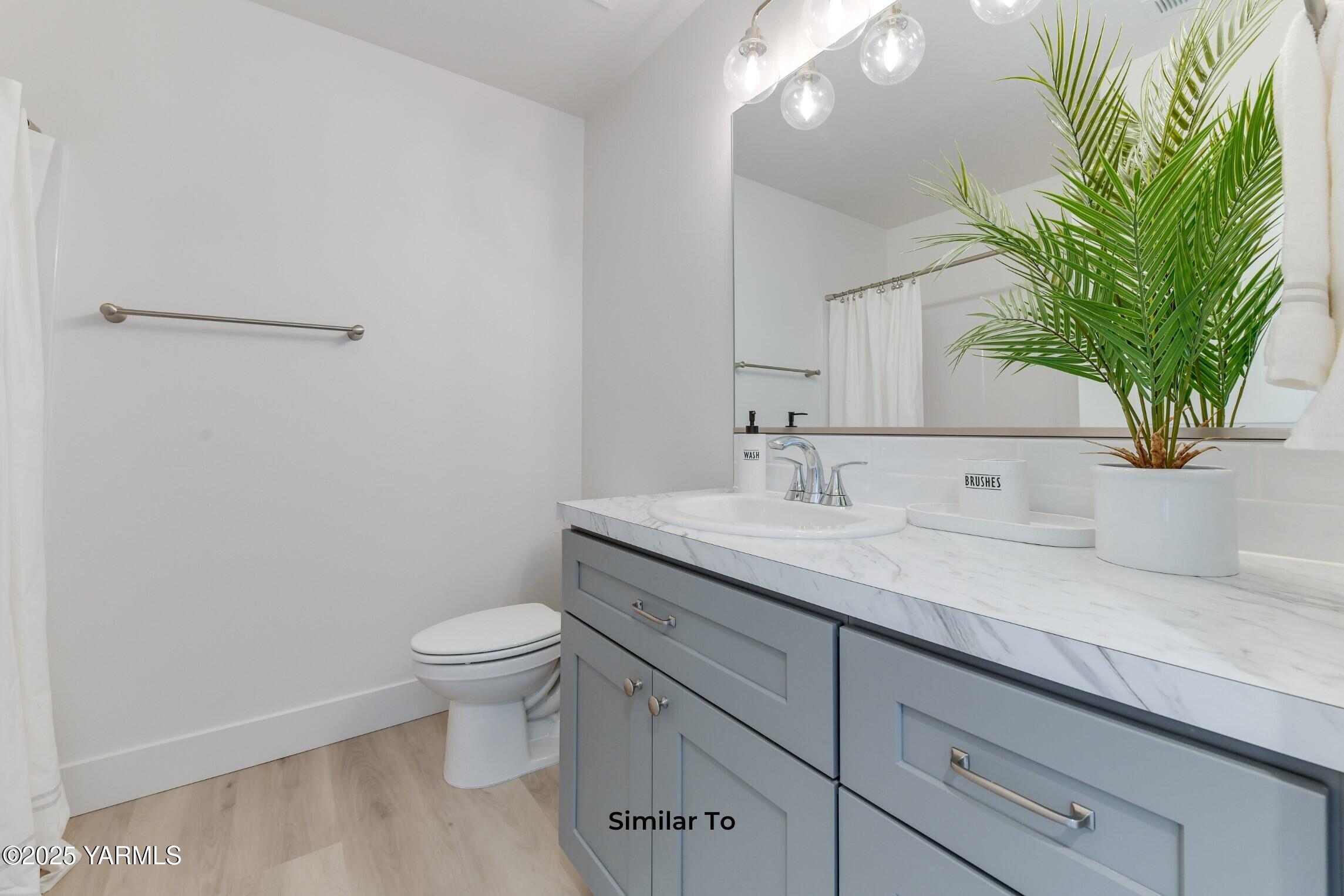 506 Grapevine Street, Unit PHASE 3 LOT 11) SPEC Grandview, WA 98930 - Photo 14 of 22 a bathroom with a granite countertop sink a toilet and mirror