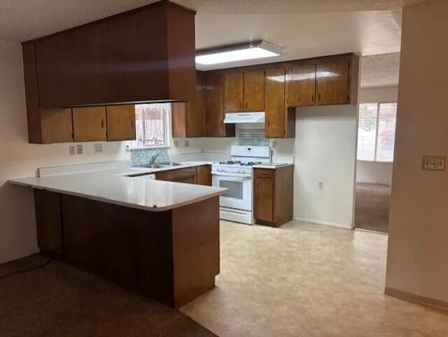 a kitchen with kitchen island a sink stove and refrigerator