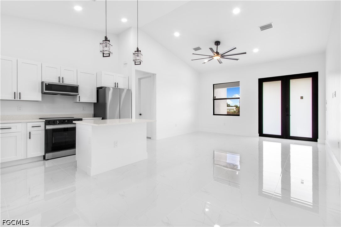 3004 South Tulip Road LaBelle, FL 33935 - Photo 7 of 24 a kitchen with kitchen island a white counter top space stainless steel appliances and a refrigerator