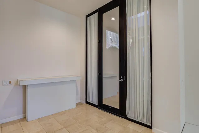 a view of an empty room with wooden floor and a fireplace