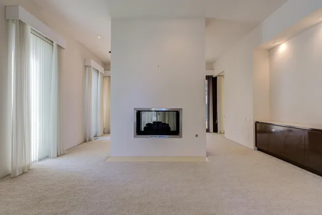 a view of an empty room with a fireplace and a window