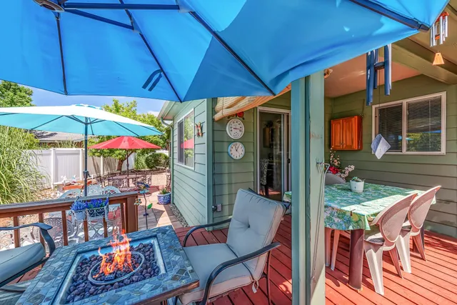 a view of a backyard with a table and chairs under an umbrella